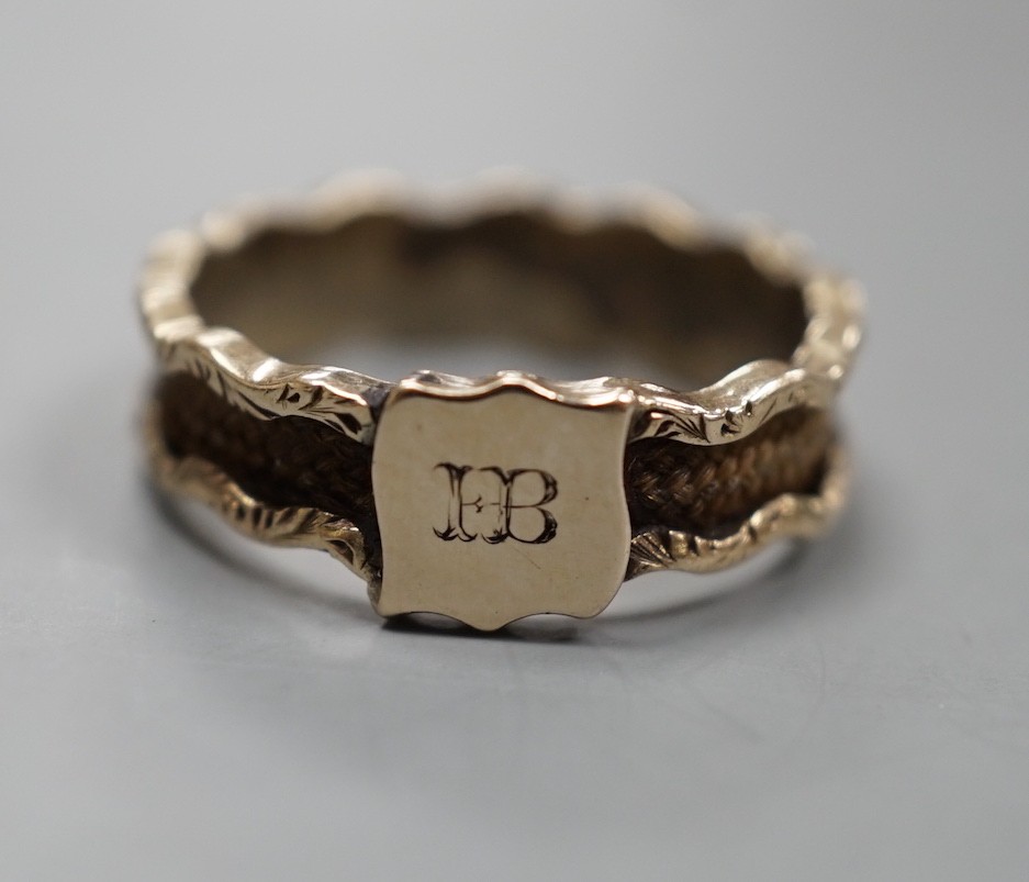A 19th century yellow metal and plaited hair mourning band, with engraved initial, size N, gross weight 1.7 grams.